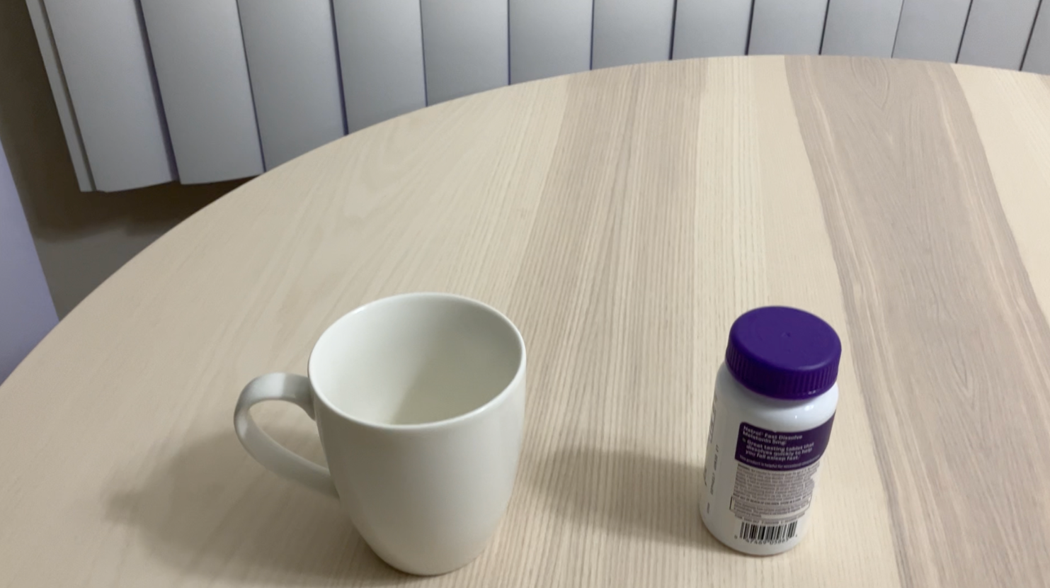 A near-identical photo of the same mug and bottle from a slightly different angle, the second of two near-identical frames.